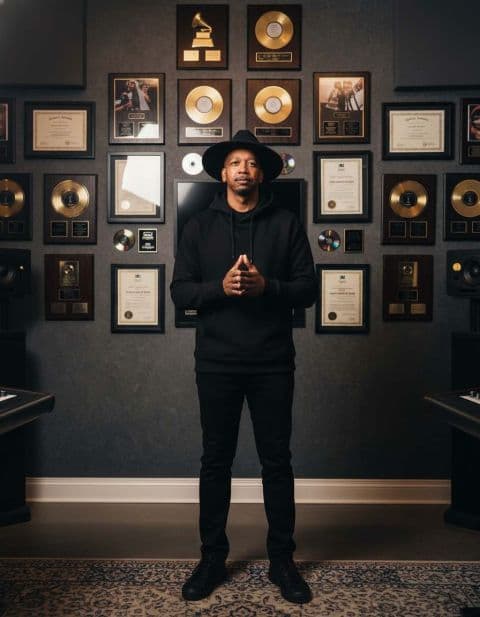 Marcus Bell, founder of Bellringer Productions, in front of plaques